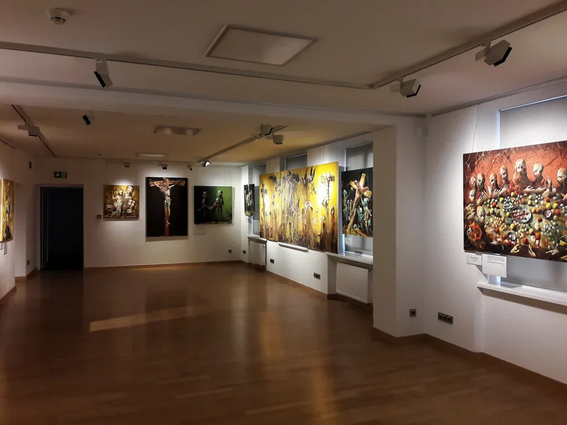 Sala sztuki współczesnej w Muzeum Archidiecezji Warszawskiej z surrealistycznymi obrazami o tematyce religijnej