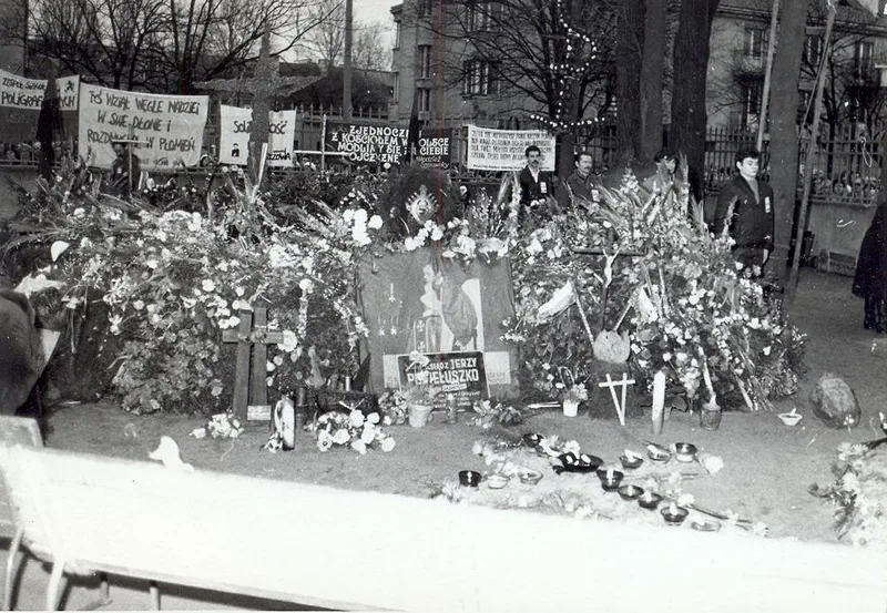 Kwiaty, wieńce i transparenty Solidarności złożone na grobie ks. Jerzego Popiełuszki podczas pogrzebu w listopadzie 1984 roku