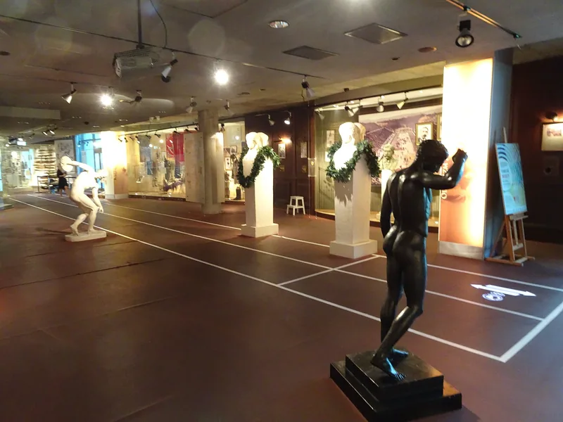 Sala wystawy stałej Muzeum Sportu i Turystyki z odlewami antycznych rzeźb sportowych ustawionymi na podłodze imitującej bieżnię