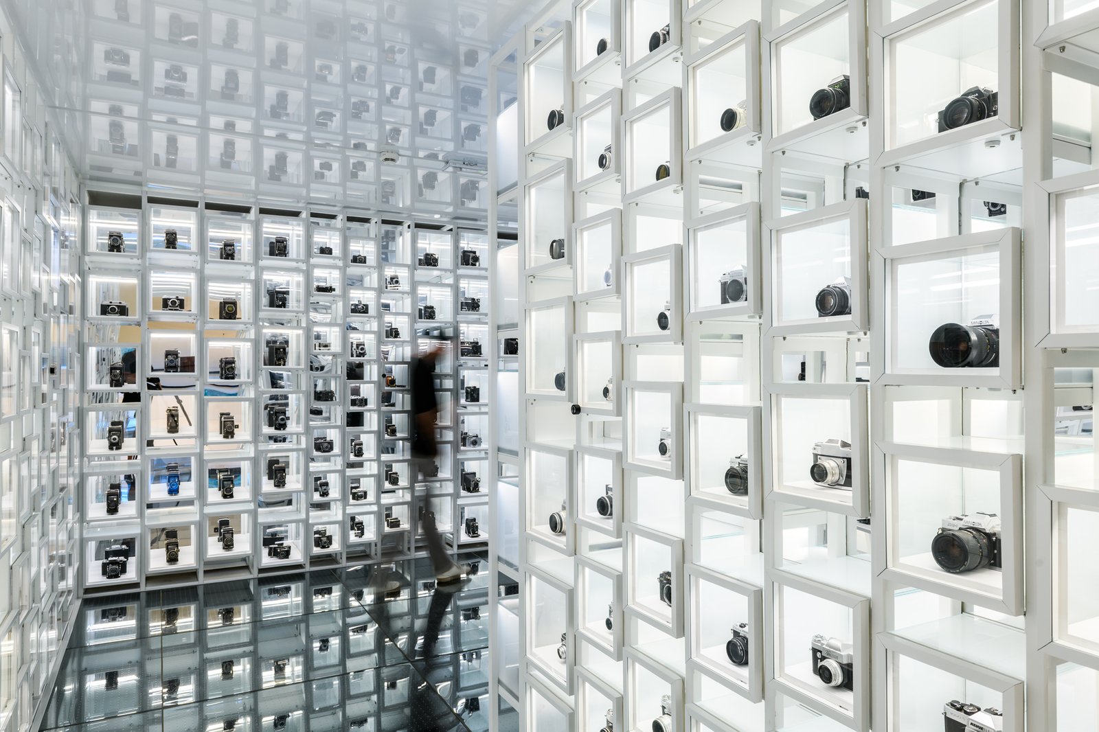 A white wall of cameras in illuminated cells at the Museum of Photography in Krakow, Rakowicka street